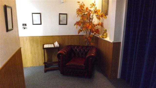 Brown & white funeral room with dark red leather arm chair