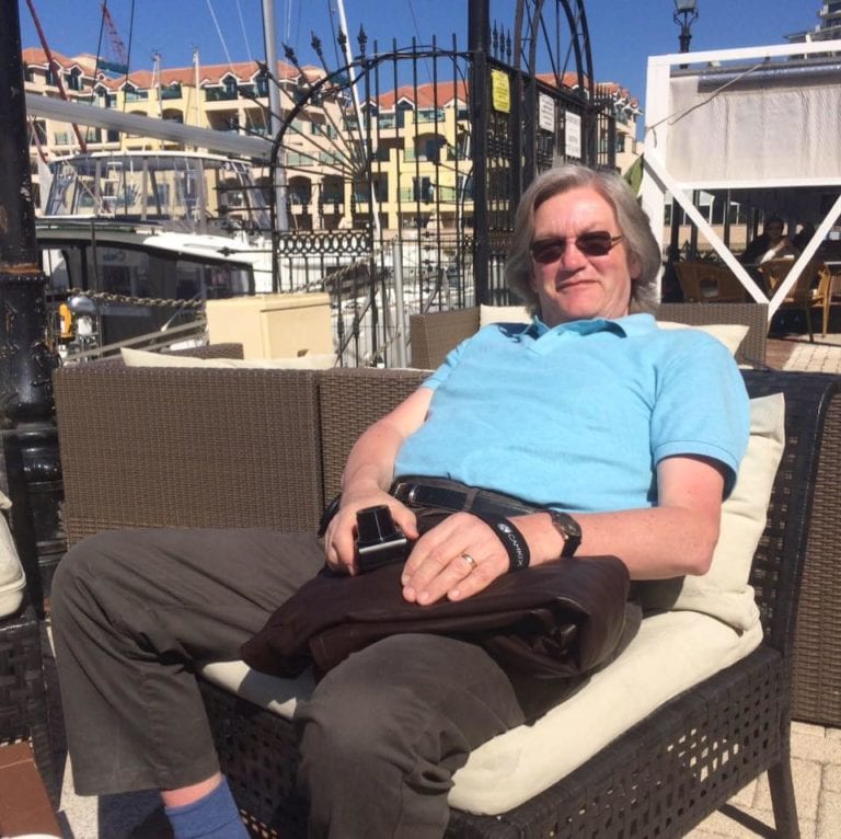 Photo of T Allen founder Terry Allen sitting on a chair down the coast enjoying family time